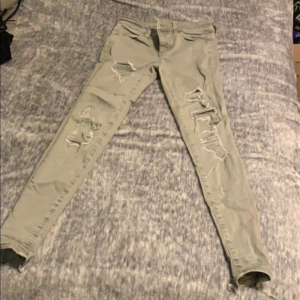 Green ripped jeans with patched holes